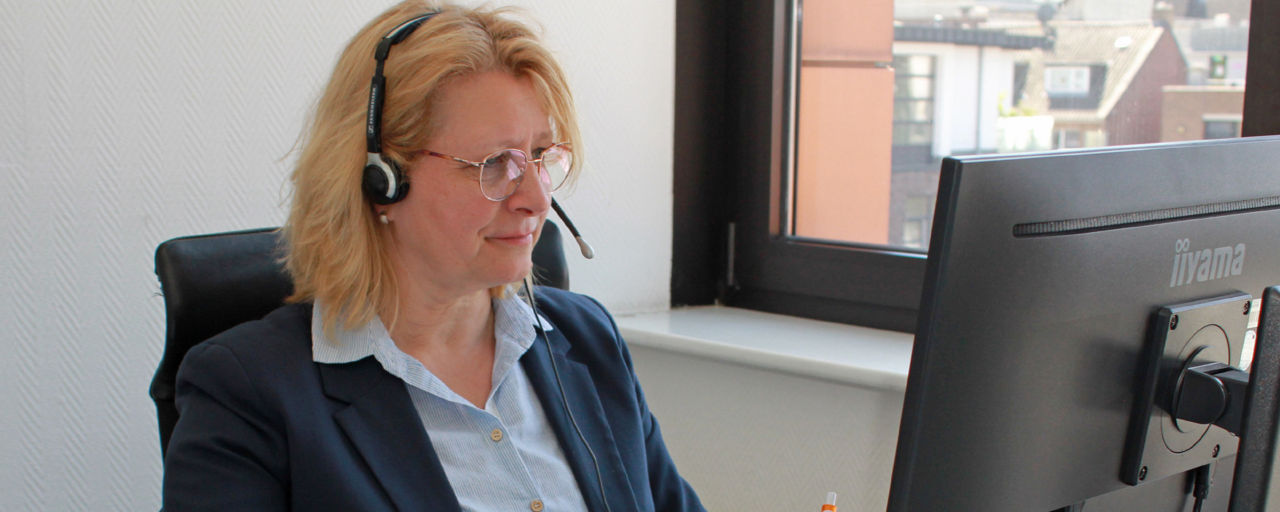 Mitarbeiterin am Telefon vor ihrem Rechner