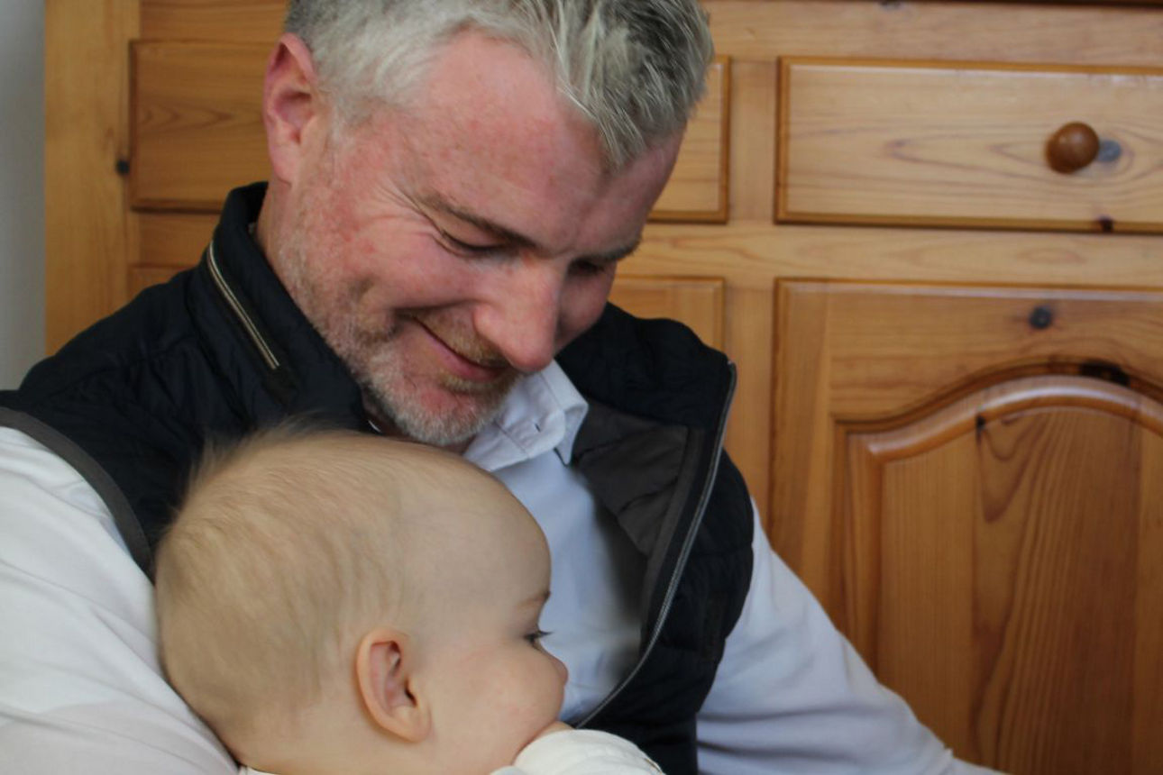 Mann mit Baby auf dem Arm