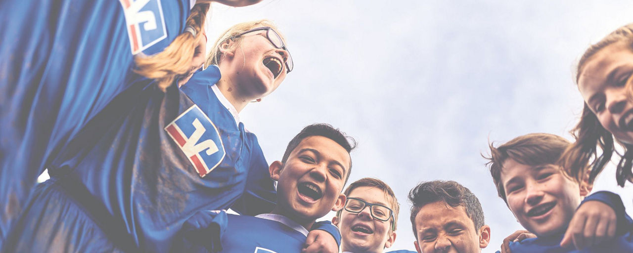 Kinder in Trikots stehen zusammen und freuen sich