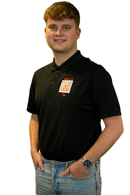 Junger Berufstätiger in einem schwarzen Poloshirt, hellen Jeans und einer Armbanduhr.