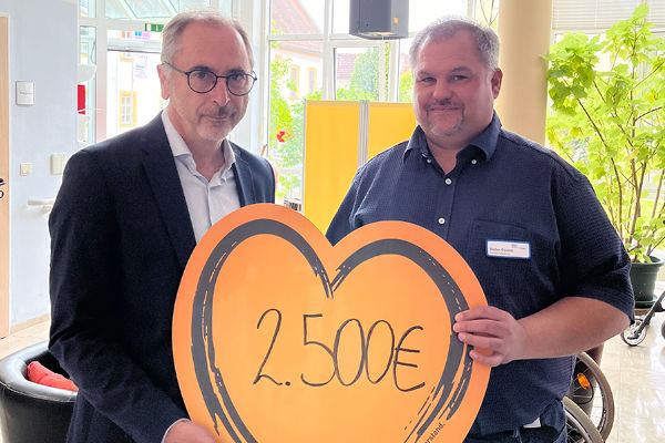Rüdiger Ebert übergibt eine symbolische Spende an das Altenheim