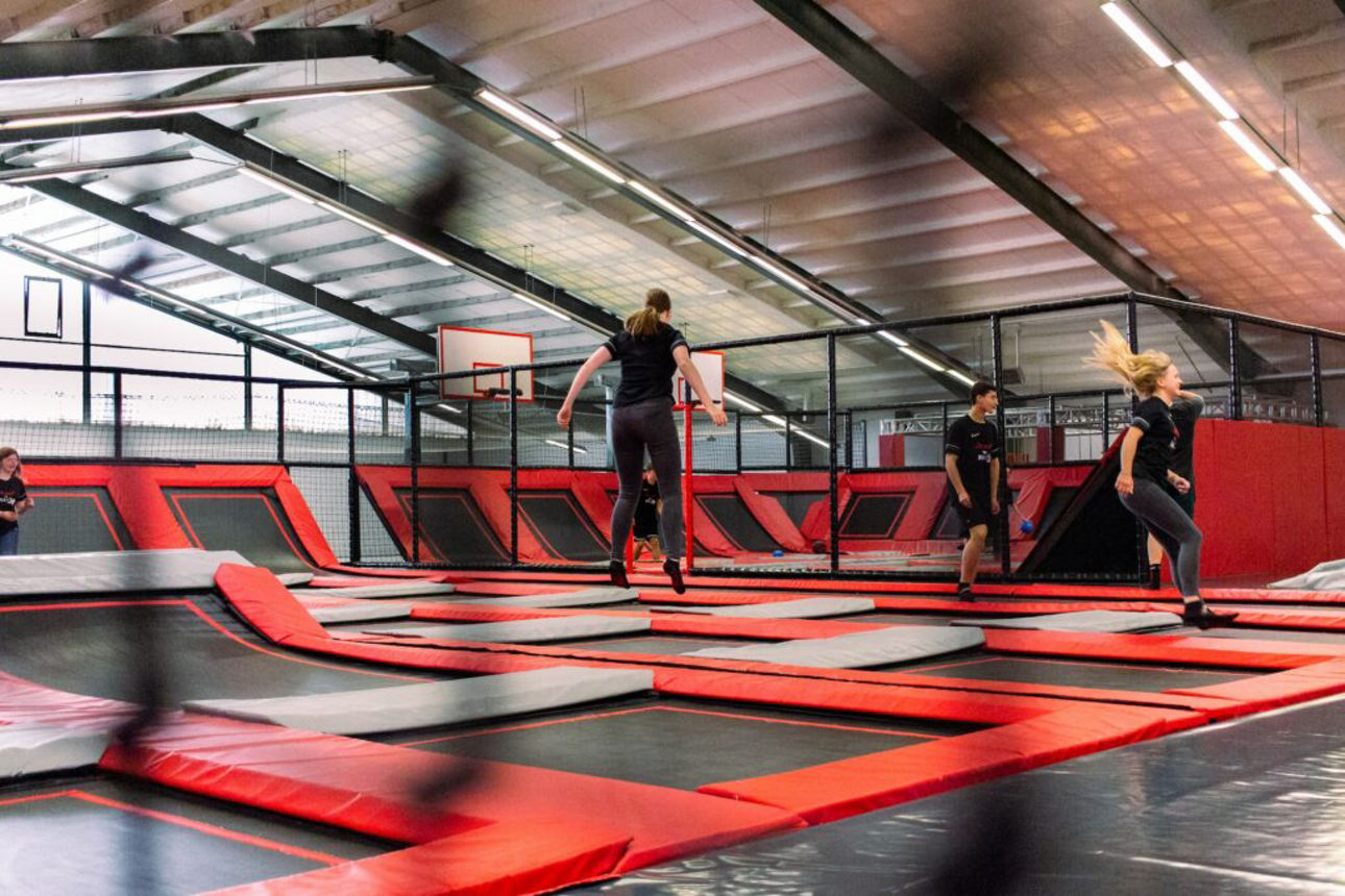 Kinder springen auf Trampolinen in einer Trampolinhalle