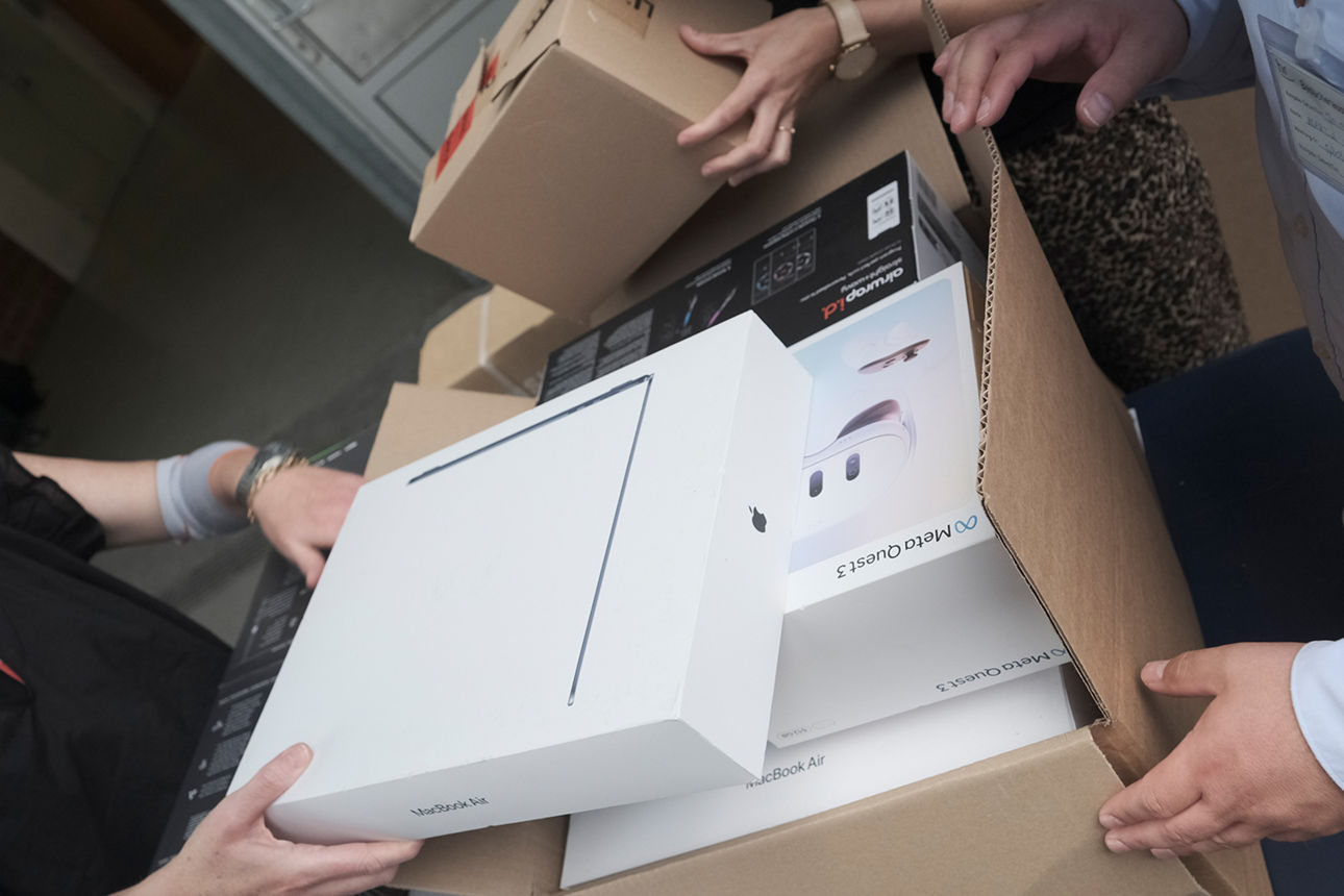 Pakete voller Technikprodukte vor einem Tor