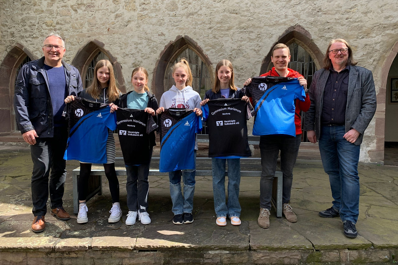 Eine Tischtennismannschaft, die neue Trikots übergeben bekommt