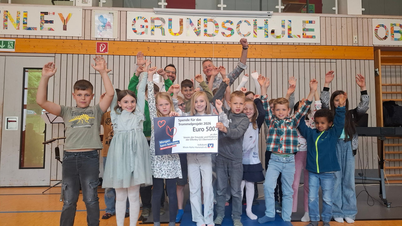 Kinder halten einen Spendenscheck in der Hand.