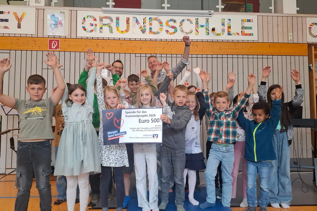 Kinder halten einen Spendenscheck in der Hand. 