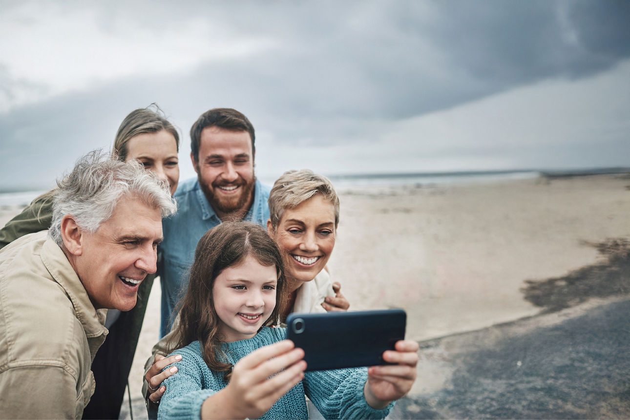 Eine Familie die geimsan auf ein Handy schauen.