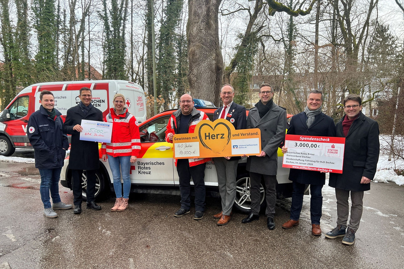 Spendenübergabe mit Vertreter der Stadt Dachau, VR Dachau, Sparkasse Dachau und dem BRK Dachau vor einem Auto.