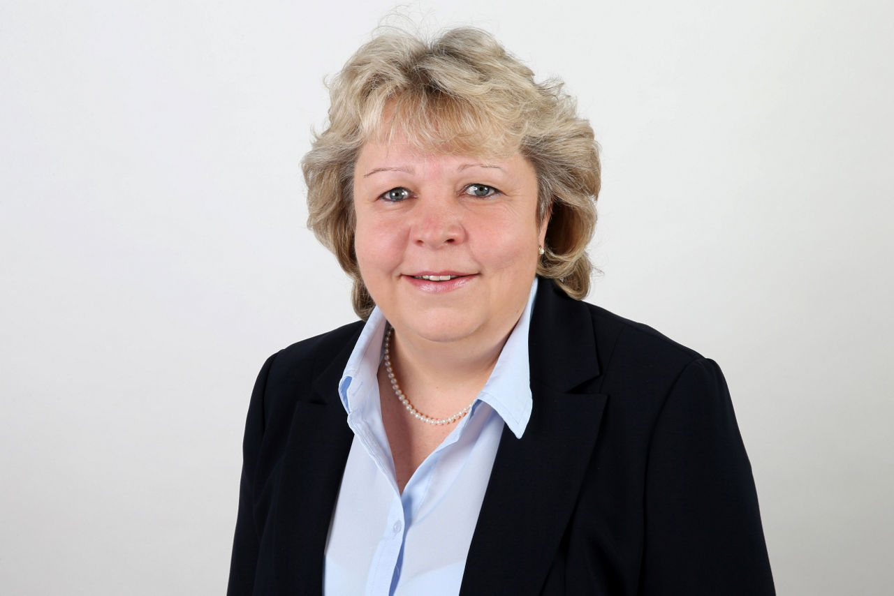 Eine lächelnder Frau schaut in die Kamera.