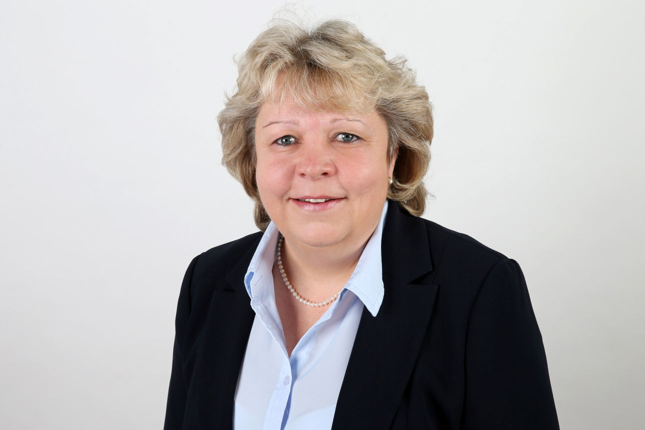 Eine lächelnde Frau schaut in die Kamera.