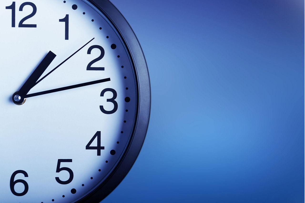 Eine halbe Wanduhr vor blauem Hintergrund