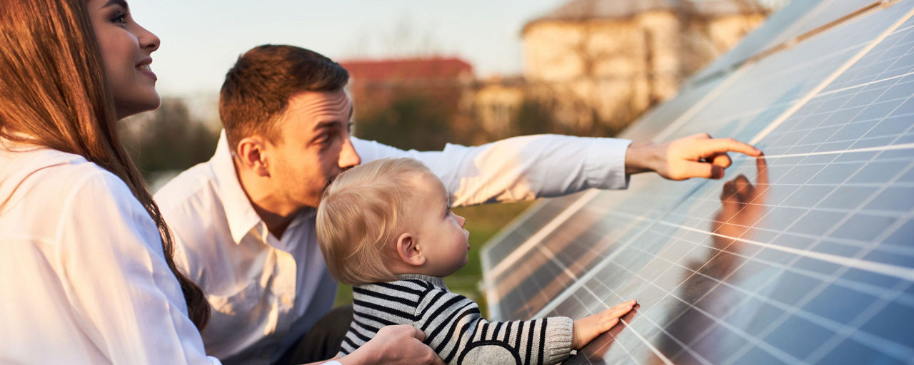 Familie steht an Solarpaneelen