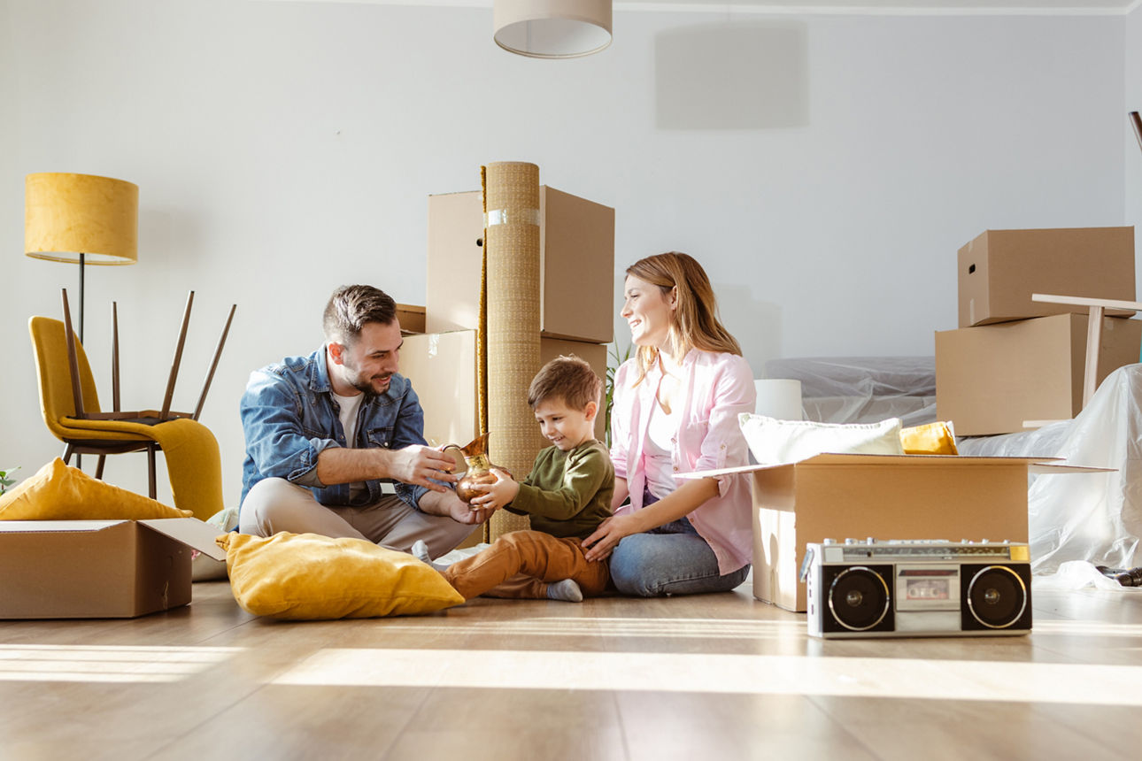 Umzugsraum mit Möbeln und Kartons und einer Familie mit Kind