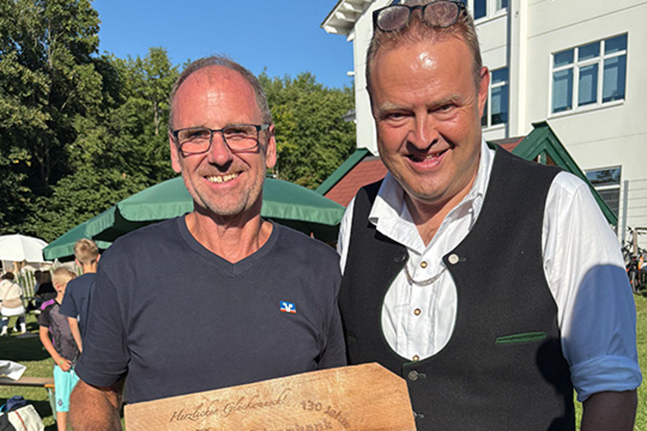 Zwei Männer halten ein Schild.