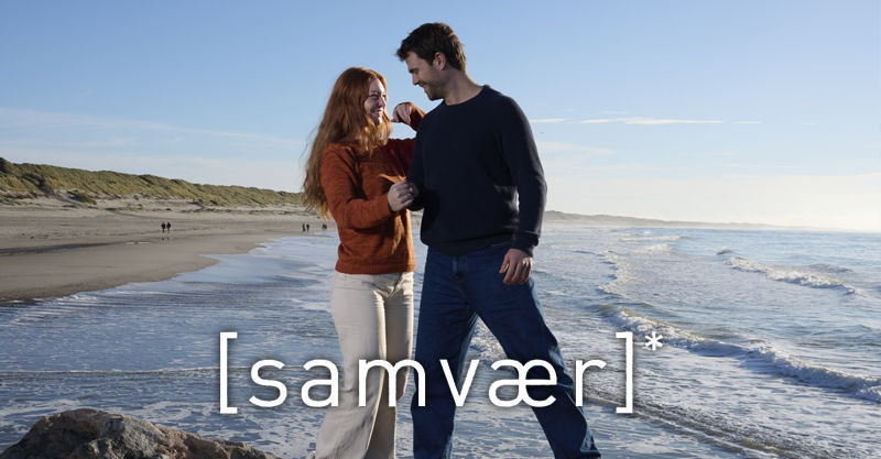 Zwei Personen laufen am dänischen Strand