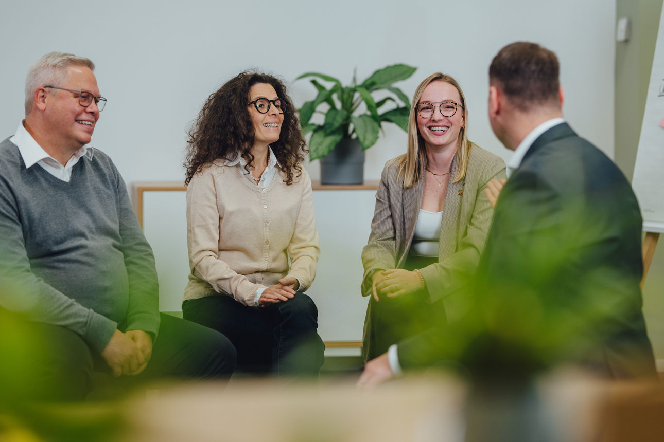 Vier Mitarbeitende unterhalten sich im Büro