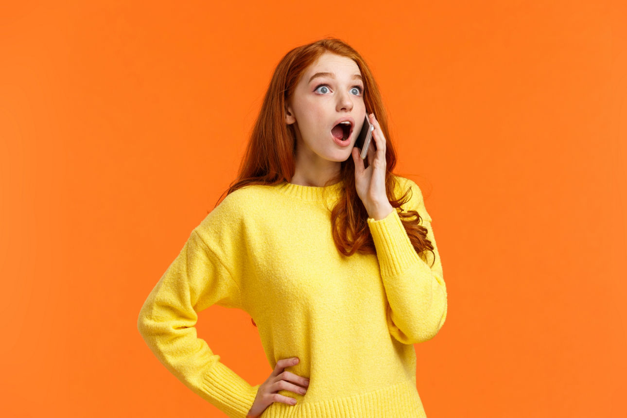  Eine Frau in einem gelben Pullover ist in ein Telefongespräch vertieft.