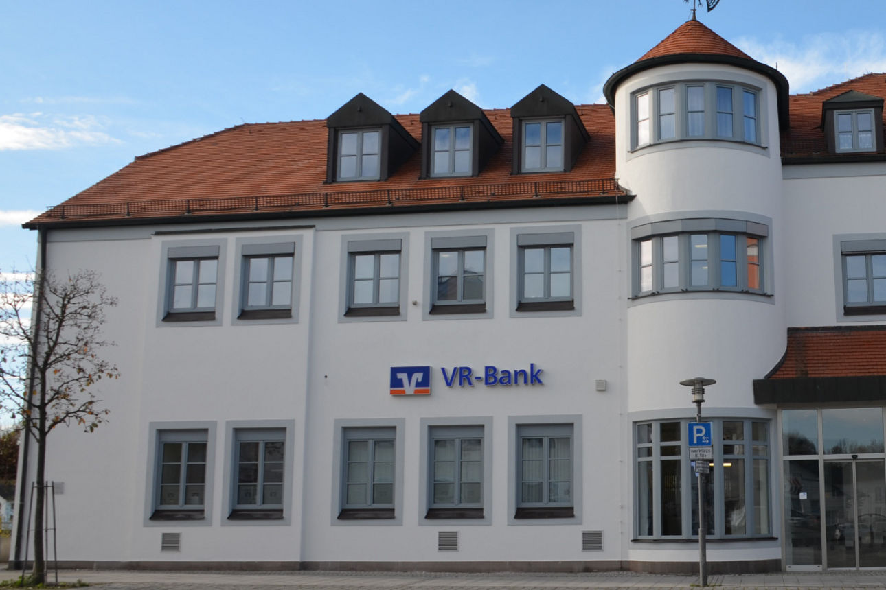 Unsere Geschäftstelle in Geisenhausen. Ein großes weißes Gebäude.