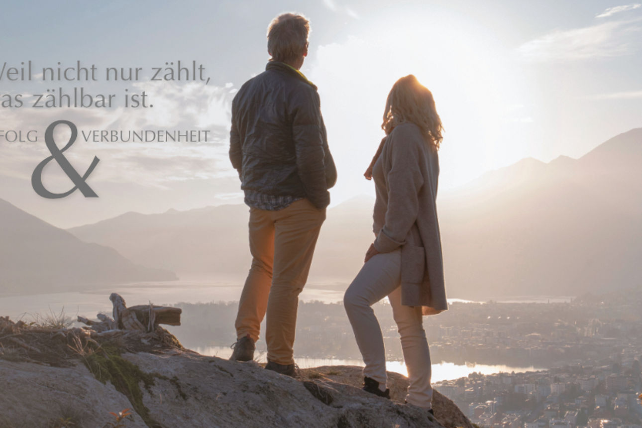 Mann in Sitzgruppe schaut aufs Handy