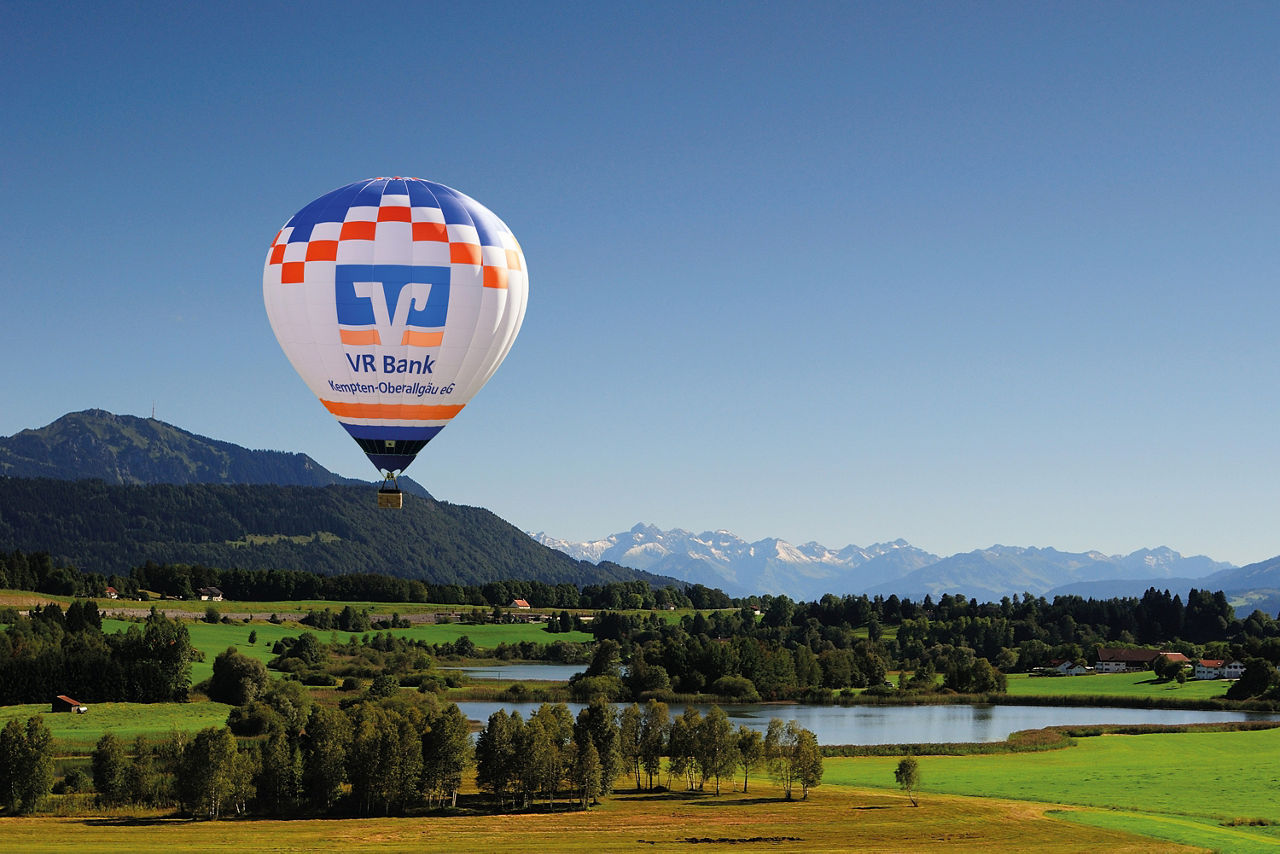 Blick auf den Niedersonthofener See mit Ballon der VR Bank