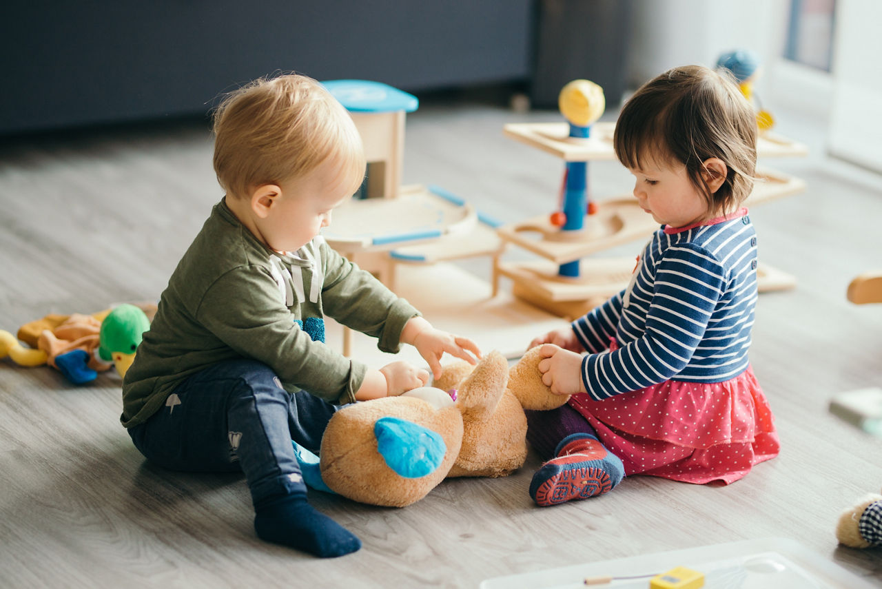 cute little girl and boy playing with toys by the home