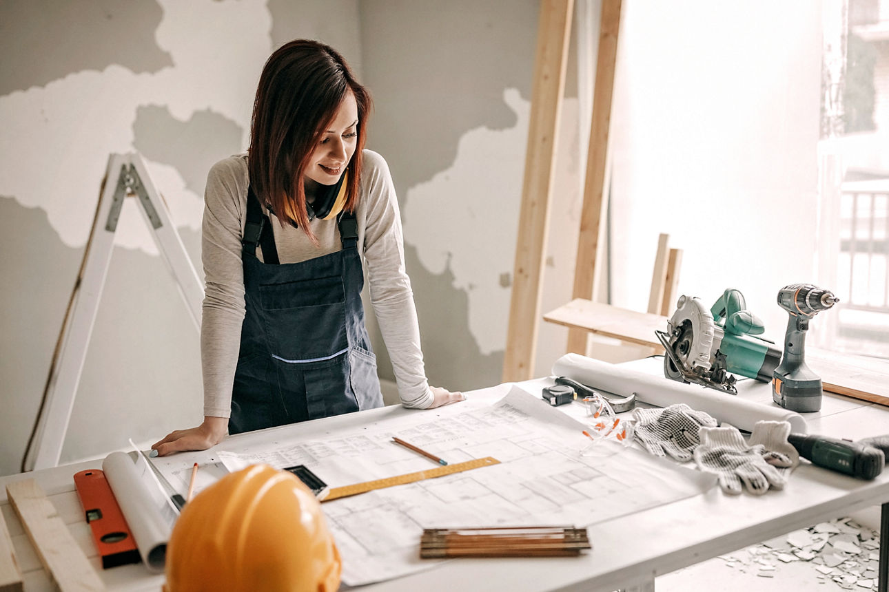 Frau schaut sich Baupläne an