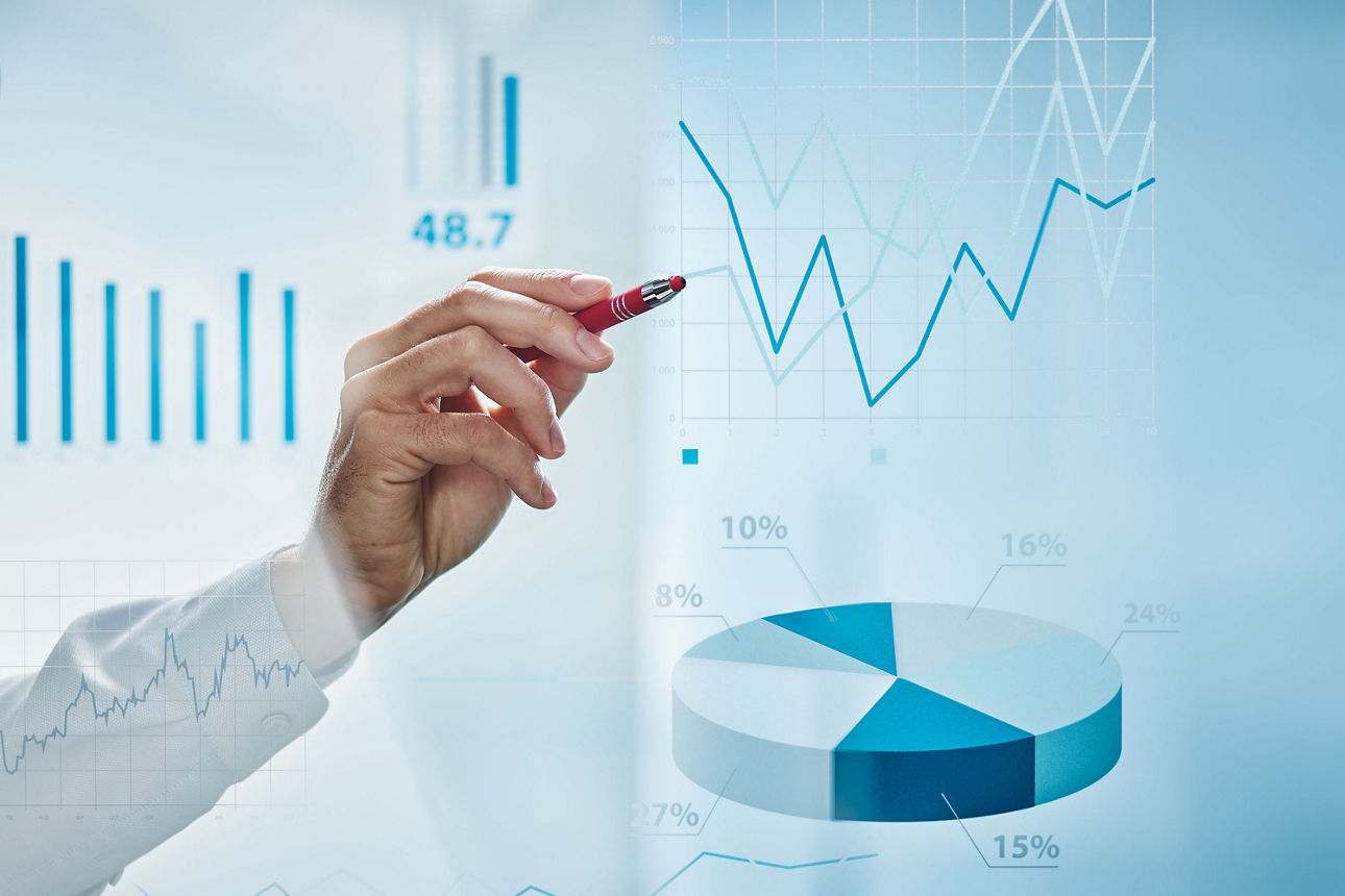 Eine Hand mit Stift zeichnet auf einer Glaswand.