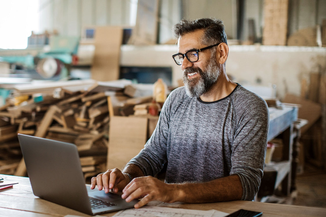 Unternehmer arbeitet in seiner Firma am Laptop