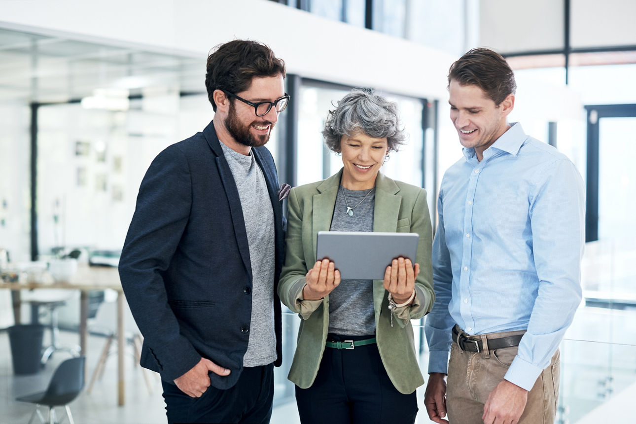 Geschäftskollegen arbeiten zusammen und besprechen Projektdetails auf einem Tablet