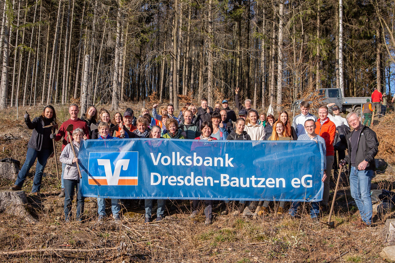 Gruppenfotos Frauen und Männer im Wald bei einer Baumpflanzaktion