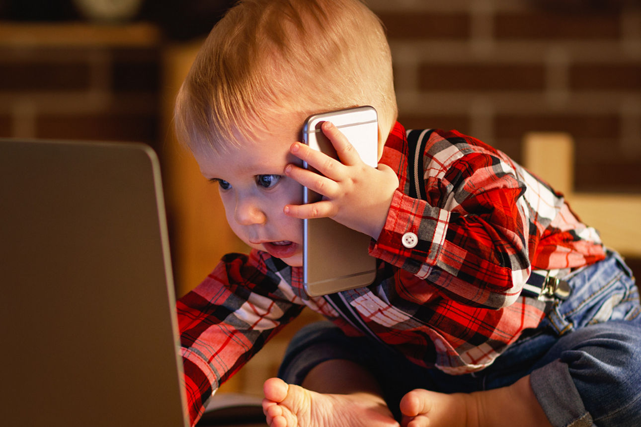 Ein Baby schaut auf einen Laptop