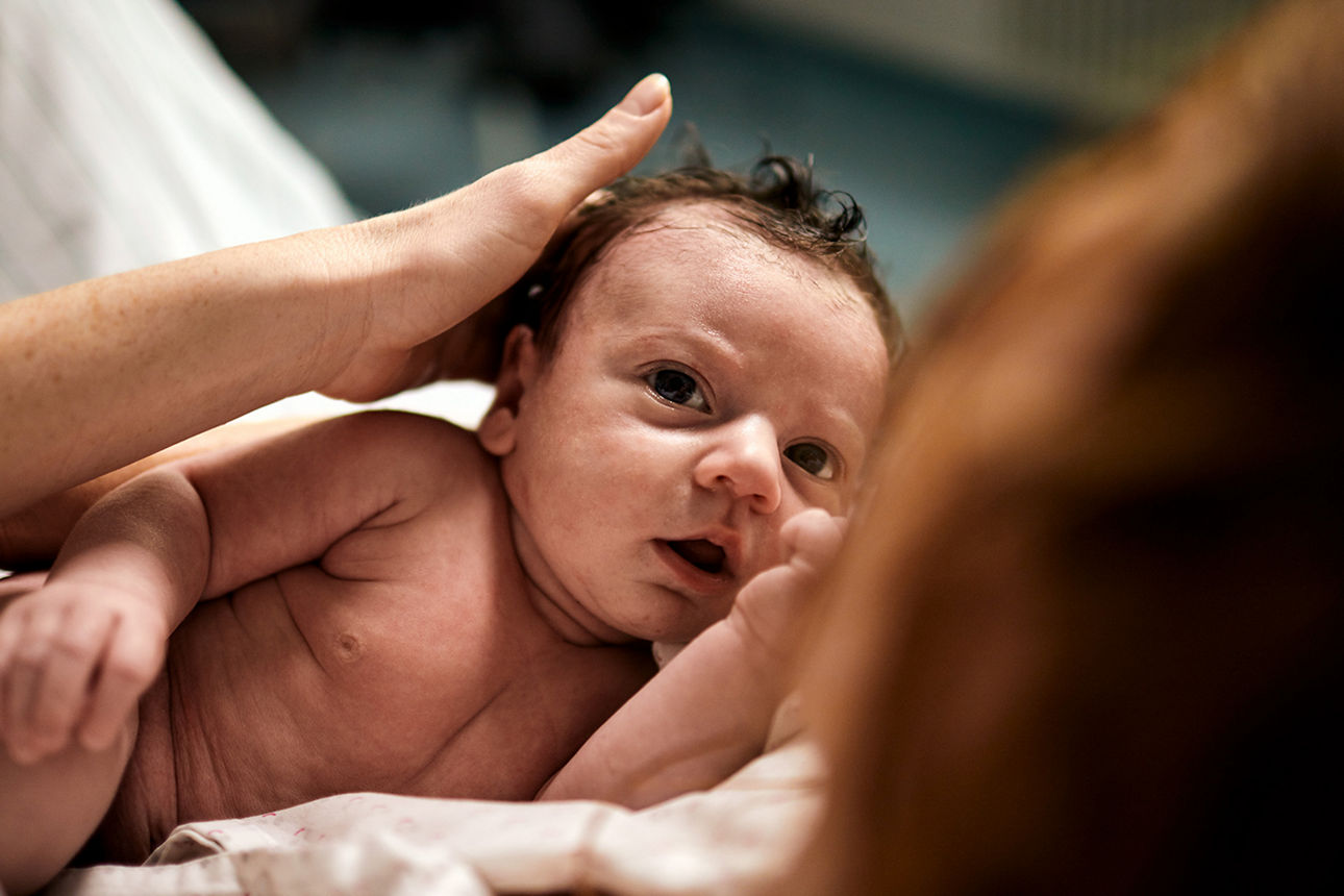Eine Mutterhält ein Neugeborenes auf dem Arm