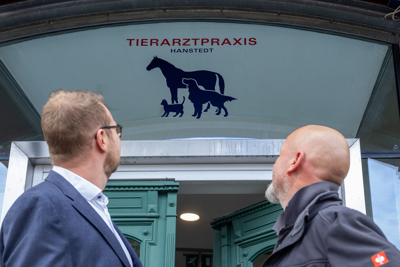 Dr. Jörg Kaling und Christian Vorbrodt vor Praxis Logo in Hanstedt