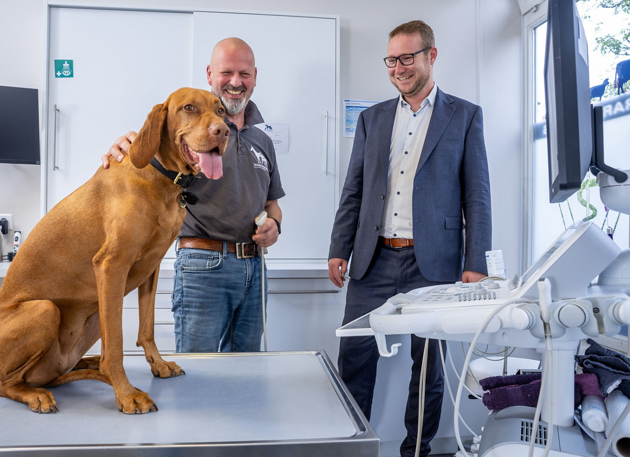 Dr. Jörg Kaling und Christian Vorbrodt in Behandlungsraum mit Hund