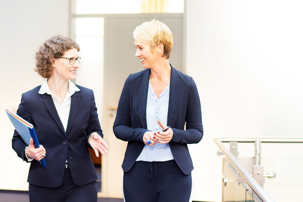 Zwei Bankberaterinnen sprechen gemeinsam über Unterlagen