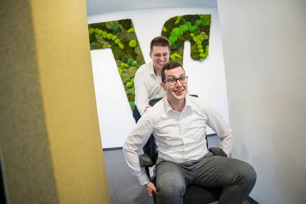 Zwei Azubis der VBBS auf einem Bürostuhl
