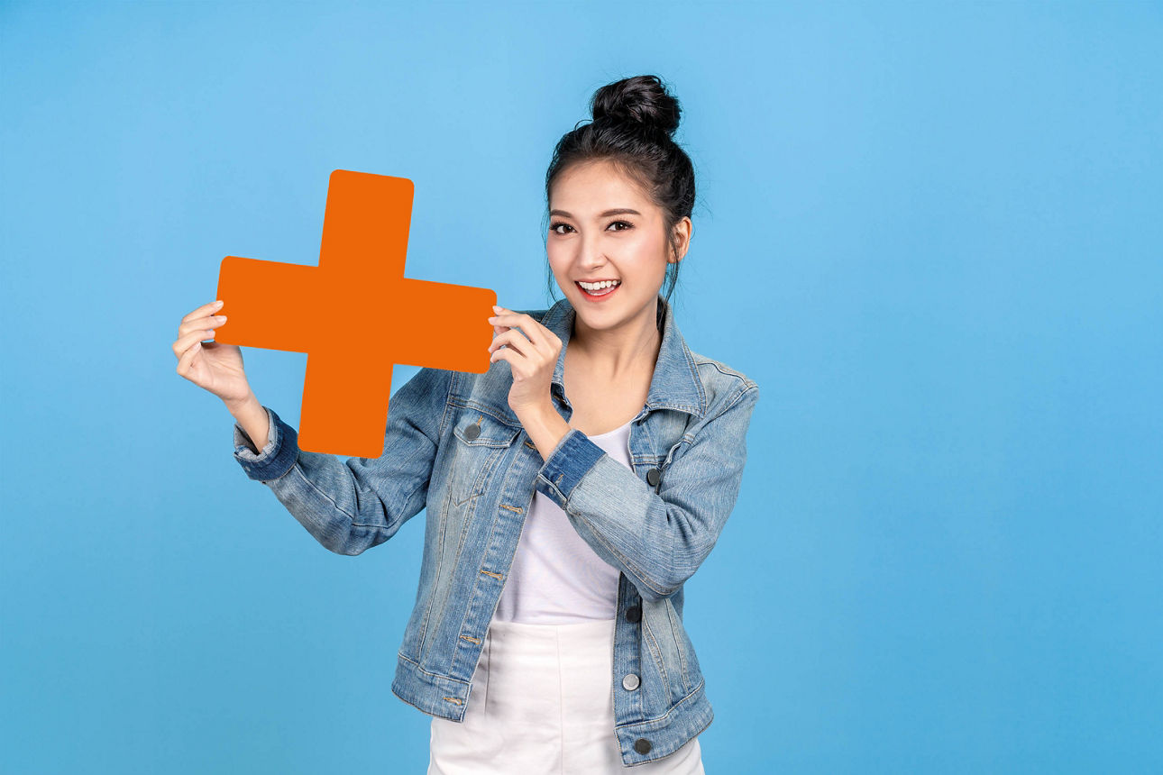 lachende Dame mit orangenem Plus in der Hand für Mitgliedschaft