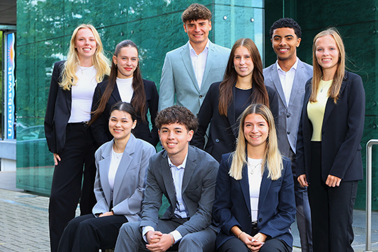 Sechs junge Frauen und drei Junge Männer als Gruppe in Businessoutfit