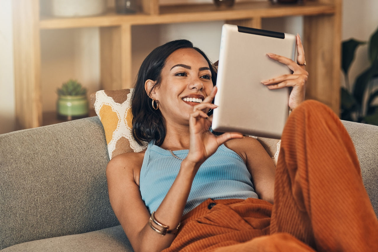 Frau auf Sofa mit Tablett online zur Kontenwechselhilfe