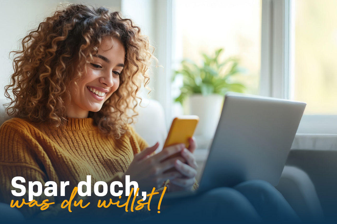 Junge Frau sitzt auf der Couch vor dem Fenster mit Laptop und Smartphone in der Hand