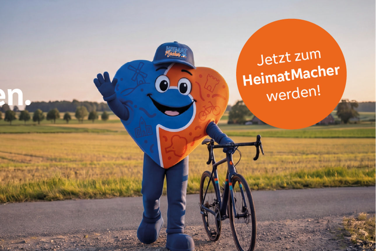 HeimatMacher Maskottchen vor einem Feld