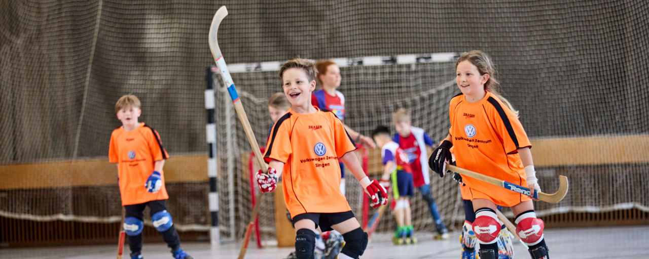 Mehrere Kinder beim Rollhockey spielen