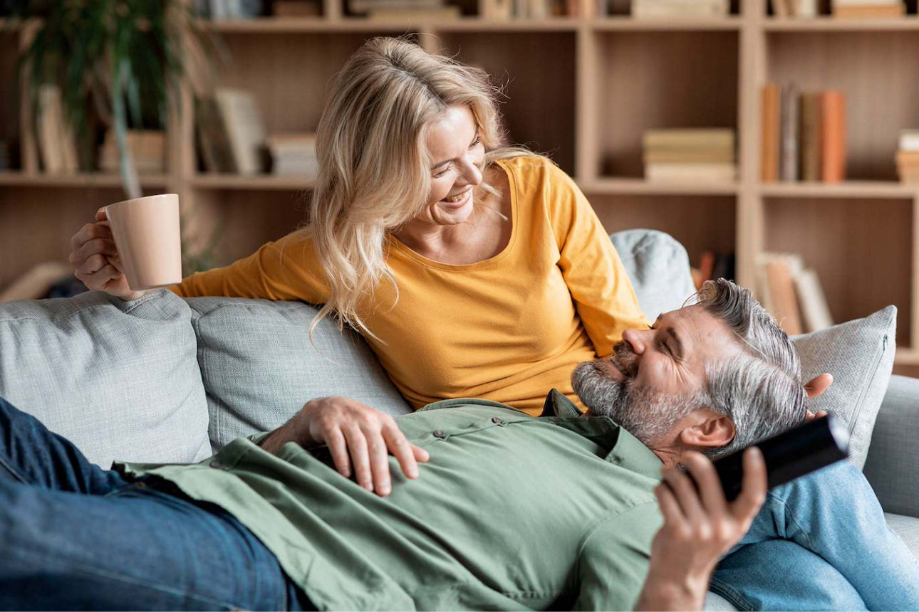 Eine Frau und ein Mann glücklich und lächelnd auf einer Couch