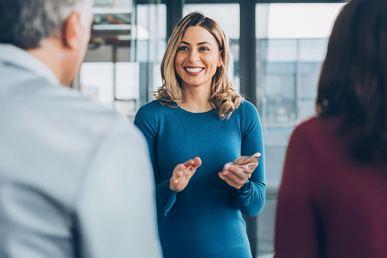 Eine junge freundliche Frau im Gespräch mit einem Paar