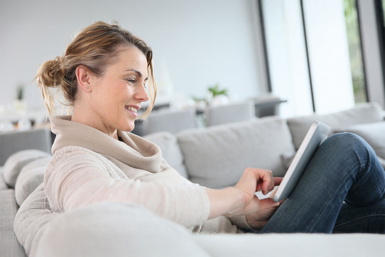 Frau schaut entspannt auf ihr Laptop