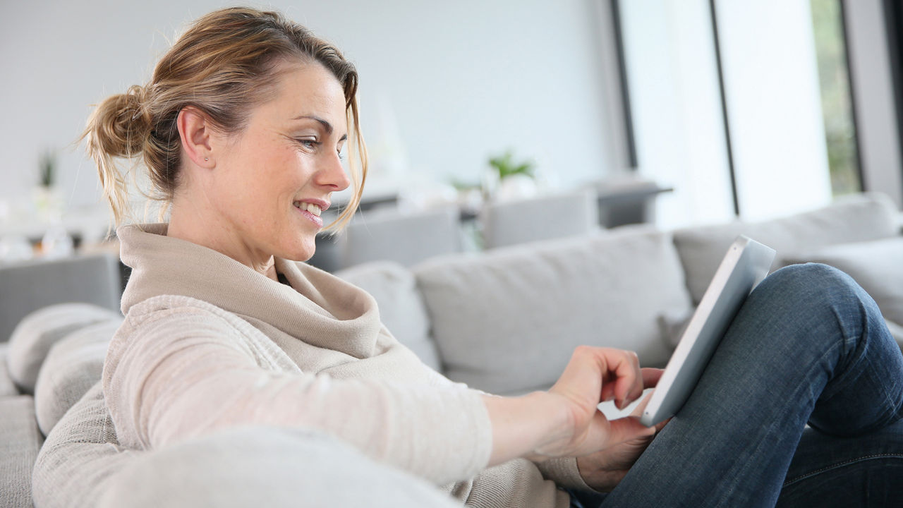 Frau schaut entspannt auf ihr Laptop
