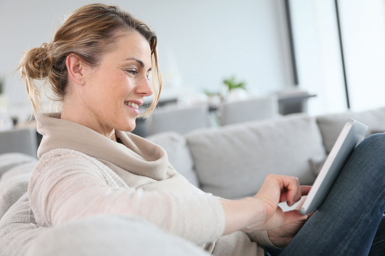 Frau schaut entspannt auf ihr Laptop