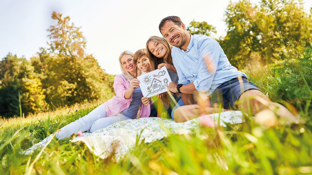 Familie sitzt in einer Wiese