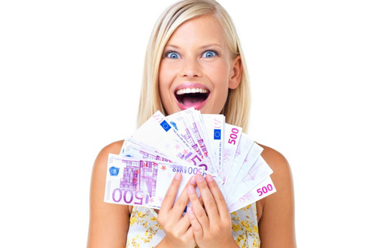 Eine Frau zeigt stolz eine Handvoll Bargeld