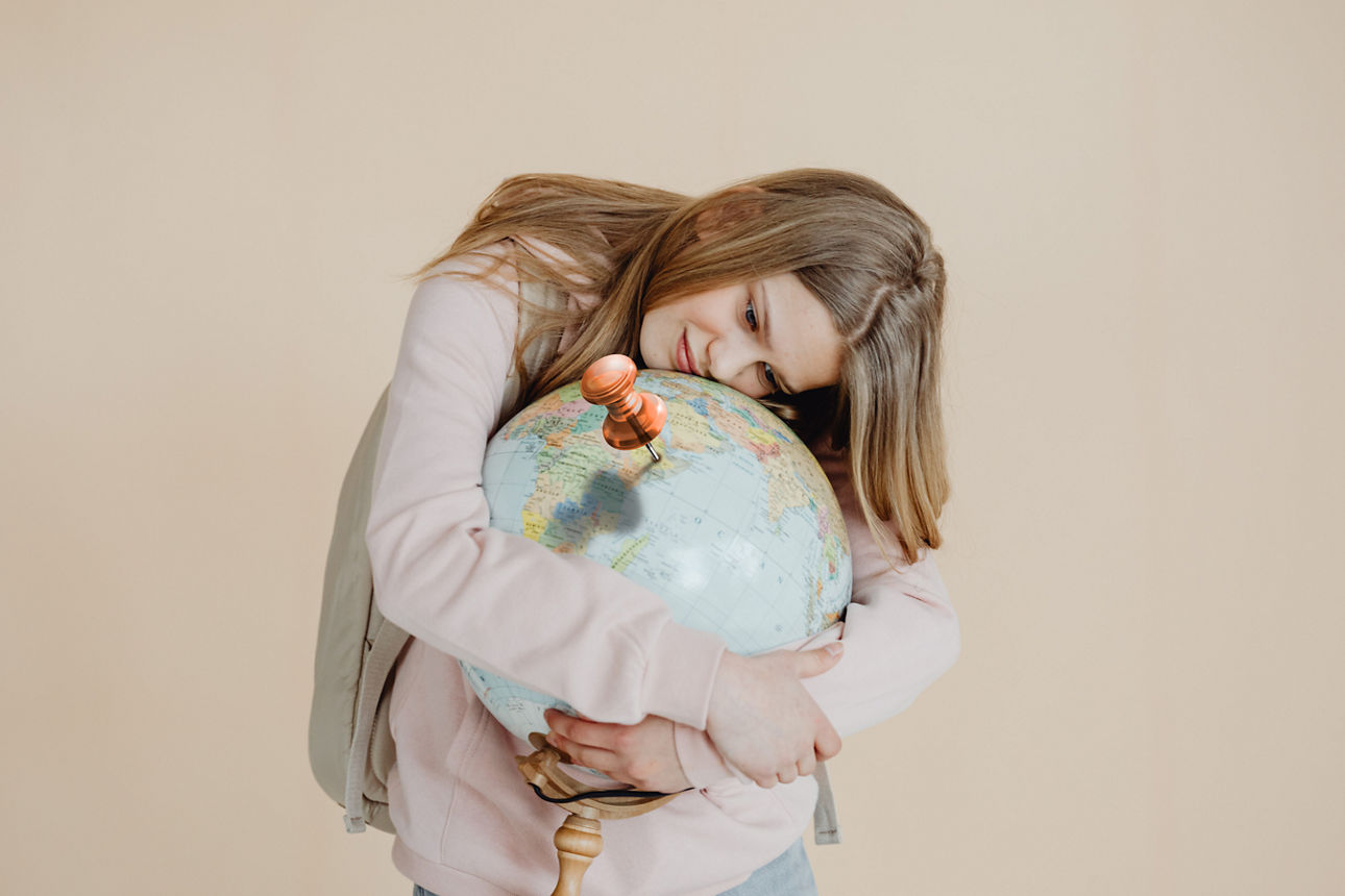Mädchen, das Weltkugel umarmt